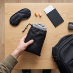 NapHug packed into its small carry bag next to travel essentials